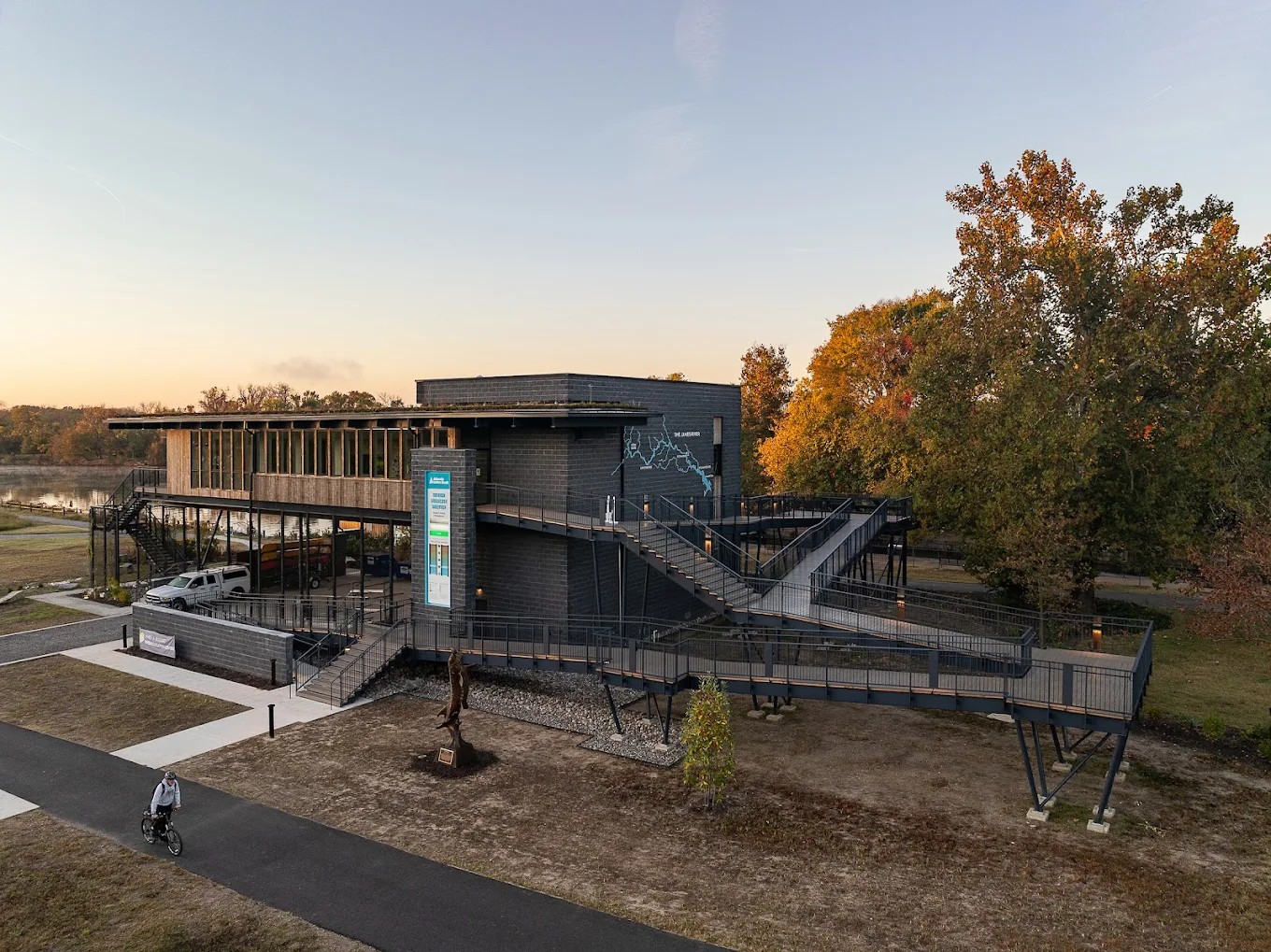 The James A. Buzzard River Education Center beside the river, with its elevated walkway and autumn trees